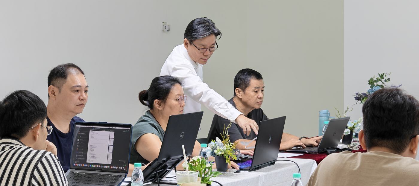 老师在学员旁边讲解屏幕上的内容